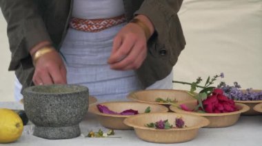 Usta sınıfındaki sauna görevlisi sauna için vücut önlüğünün nasıl tuz, soda ve çeşitli bitki ve çiçeklerden yapıldığını gösteriyor..
