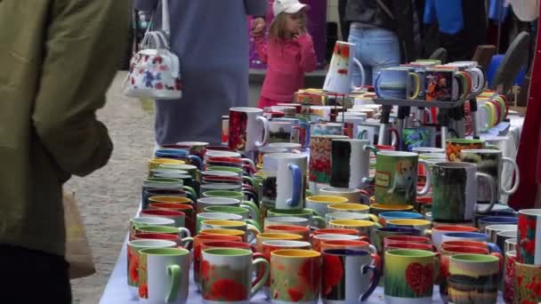 個々の生産物が立っている ストリートセールスタンドで印刷された陶磁器のカラフルなカップ 町の祭りの時間の小規模なビジネス市場活動の一部 — ストック動画