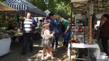 Küçük işletme sokak satışları. Mücevher standındaki insanlar. Yazın bir kasaba festivali sırasında kentsel çevrede ticaret stantları.