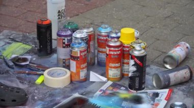 Riga, Letonya - 10 Eylül 2021. Bir sokak sanatçısının cephaneliği. Sokak yüzeyinde düzgünce düzenlenmiş bir dizi aerosol boya sergilerken bir sokak sanatçısının canlı paletini keşfedin.