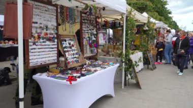 Dobele, Letonya - 3 Haziran 2023. Açılıp saçılan marketteki insanlar. Şehir festivali sırasında el sanatları ve kostüm perakendecilerinin sokak satışı tezgahları.