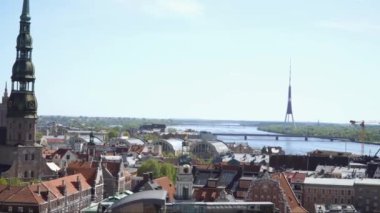 Riga, Letonya - 2 Mayıs 2024. Letonya başkentinin şehir merkezindeki hava manzarası. Riga eski kasabasından, güneşli bir bahar gününde nehrin karşı yakasına kadar uzanan panoramik manzara..