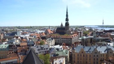 Riga 'nın hava manzarası şehir manzarasını yakalar ve ikonik St. Peter' s Kilise Kulesi 'ni gösterir. Bu manzara, aydınlık ve güneşli bir günde Daugava Nehri yakınlarındaki Letonya başkentinin mimarisini gösteriyor..