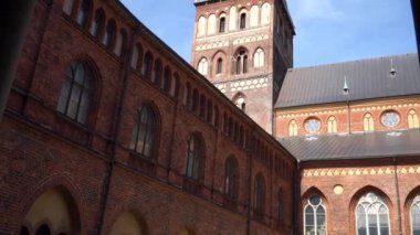 Riga Katedrali 'nin panoramik manzarasında Riga Dome Kilisesi' nin etkileyici yüzü görülüyor. Kanonik mimari detaylarını ve merkez kulelerini vurguluyor. Tarihi bir yapı..