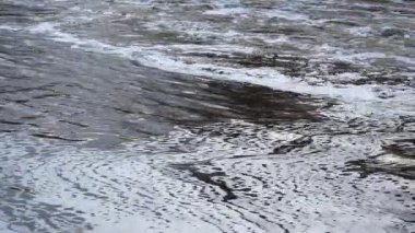 Nazikçe dalgalanan nehir suyu akışı yüzeydeki büyüleyici akış ve köpük desenleriyle vurgulanır. Işık ve suyun etkileşimi dinamik dokular ve büyüleyici görüntüler yaratır..