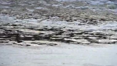 Dinamik nehir, suyun sualtındaki bir bölgeye hücum etmesi gibi beyaz köpükle dalgalanır. Yansıtıcı yüzey dönen akıntılarla çelişiyor. Yoğun ve dokulu bir desen oluşturuyor..