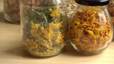 Cam kavanozlarda özenle depolanmış kurutulmuş bitkiler, çiçekler ve sebzeler. Bu ev yapımı malzemeler bitkisel çaylar, canlı renkler ve dokular için mükemmeldir..