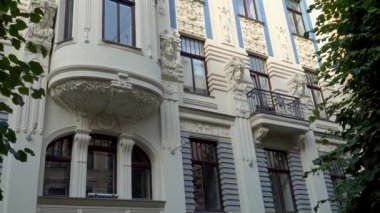 Riga, Letonya, Alberta caddesi 8 'deki ünlü Art Nouveau mimari cephesinden biri. Dekoratif unsurların ve heykellerin düşük açılı görüntüsü..