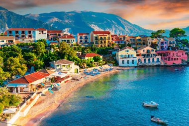 Assos, Kefalonia, Yunanistan. Avrupa 'daki cennet gibi İyon adasında renkli evler ve turkuaz renkli bir körfez.