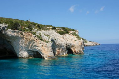 Skinari Burnu 'nun tepesindeki deniz feneri ve Yunanistan' ın Zakynthos Adası 'ndaki kayalık deniz kıyısı