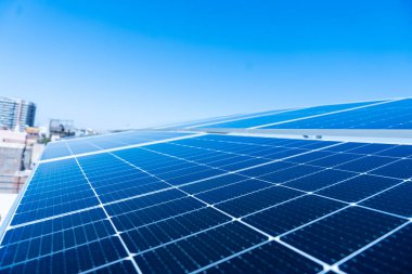 Açık mavi gökyüzü arka planına karşı güneş hücresi panelleri, sürdürülebilir kaynaklar ve yenilenebilir enerji kavramı, uzayı kopyala.