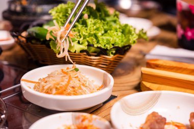 Baharatlı Kimçi grubu. Kore turşusu ya da turşu turşusu sebze seti ve sobanın üzerine baharat, ahşap masa arka planı, Japon yemeği.