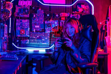 Kadınlar oyun kulaklığı takıyor evde canlı yayın esport oyun konsolu oynuyor, Oyuncular sanal turnuva oyunları için oyun kumandası kullanıyor bilgisayar neon ışıklarıyla çevrimiçi video oyunu oynuyorlar.