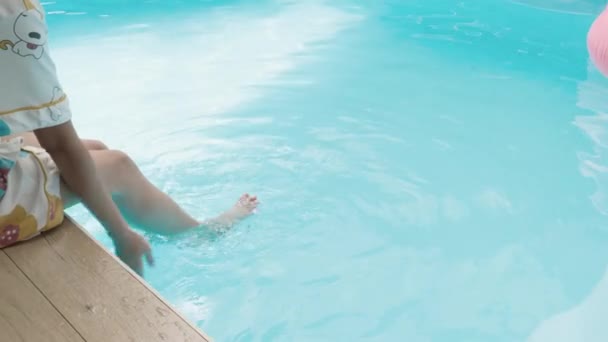 美丽的运动健美女人的腿在游泳池温泉中放松 享受夏日日光浴 女性在碧蓝的水面上飞溅的脚 度假的感觉概念 — 图库视频影像