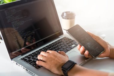 Programcı kadın iş yerinde cep telefonu program kodu arıyor, yazılım geliştirici eller dizüstü bilgisayarla veri kodlama programlama javascript, IT başlangıç konsepti, Web uygulama tasarımı