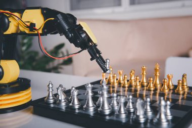 Yakın plan sarı robot kolu satranç tahtasında satranç, BTMM eğitimi E-öğrenme, Teknoloji Bilimi Robot Eğitimi konsepti