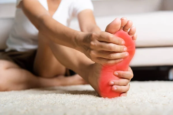 亚洲女人在家里感到脚痛 患脚痛的女人在家里用手推放松脚底的肌肉 保健问题和足部医学概念 — 图库照片