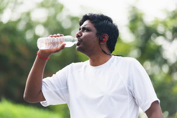 기사보기 아시아의 공원에서 달리고 젖병에서 마시는 헤드폰을 착용하고 운동에 컨셉트를 — 스톡 사진
