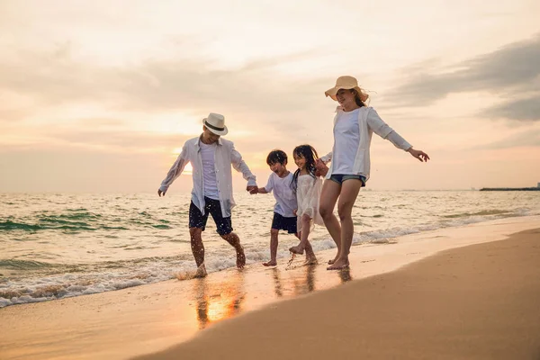 夕暮れ時の砂浜で楽しい時間を過ごしている幸せな家族 アクティブな両親と人々父 子供の息子と娘一緒にビーチを歩く 熱帯夏の休暇 — ストック写真