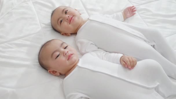 幸せな子供時代 ベッドの上でベッドの上で新生児同じ男の子の双子を寝て アジアの二つの愛らしい双子の赤ちゃん男の子 家族の人々幼児 — ストック動画