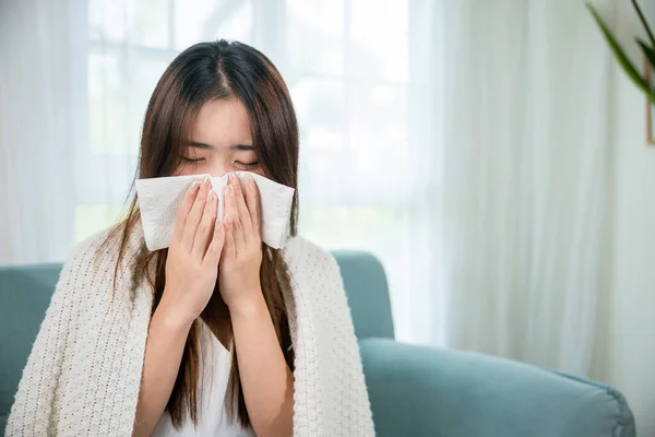 Ill Asian Young Woman Cold Covered Blanket Sitting Sofa Sneeze — 图库照片