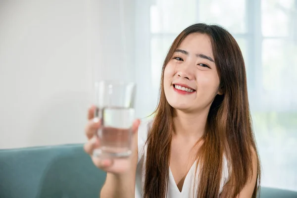 Porträtt Asiatisk Ung Kvinna Som Håller Dricksvatten Till Hands Hemma — Stockfoto