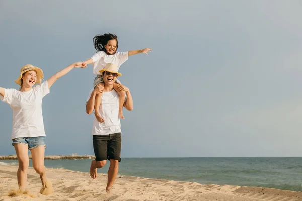 世界観光デー ビーチで夏休みを楽しんでいる幸せな人々 砂のビーチでレースを実行している休日の家族旅行 お父さん お母さんと子供の娘一緒に遊んで道路家族旅行を楽しんで — ストック写真