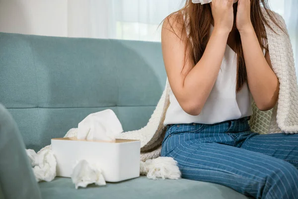病女坐在沙发上的毛毯下 用卫生纸在客厅打喷嚏 发烧感冒 生病的亚洲年轻女子在家里用卫生纸打喷嚏 医疗保健 — 图库照片