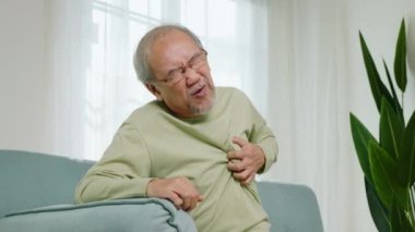 Hüzünlü son sınıf öğrencisi, kötü acı çekiyor. Göğsüne dokunuyor. Oturma odasındaki koltukta kalp krizi geçiriyor.