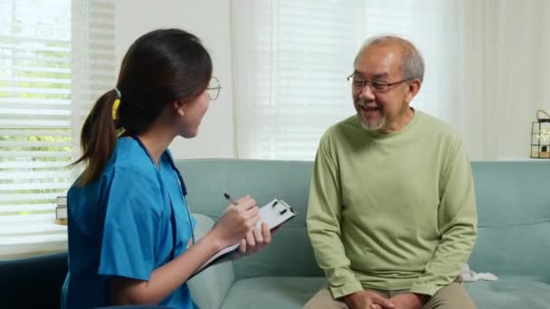 Starszy Mężczyzna Bierze Lekarza Domu Mówi Dolegliwości Zdrowotnych Azjatycka Młoda — Wideo stockowe