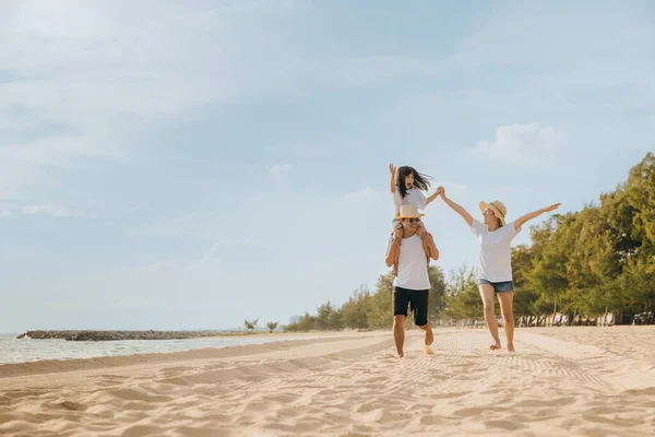 家族の日だ ビーチで夏休みを楽しんでいる幸せな家族 父親に乗っている娘 砂のビーチで走っている母親 一緒に屋外で遊んでいる家族旅行 休日に旅行 — ストック写真