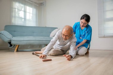 Engelli, yaşlı bir hasta bastonuyla yere düştü ve bakım evinde genç bir asistan, Asyalı yaşlı bir adam yere düştü ve kadın hemşire destek için geldi.