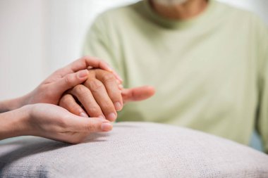 Yaşlılar için Uluslararası Gün. Genç bir kadın, evde yaşlı bir adama yardım eli uzatıyor, yaşlı bir adamın bakım merkezinden, yaşlılıktan, sağlık hizmetlerinden yardım alıyor.