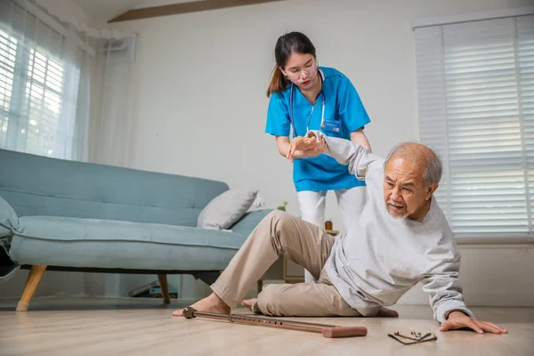 Asian older senior man falling down on lying floor and woman nurse came to help support, Disabled elderly old man patient fall down and caring young assistant at nursing home
