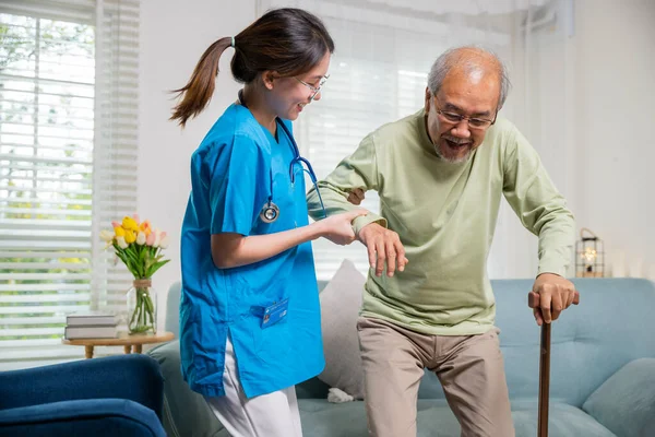 Young woman help support orthopedic patients to get up with walking cane at home, Caring nurse helping supporting senior disabled man to stand up with walking stick, International Day for the Elderly