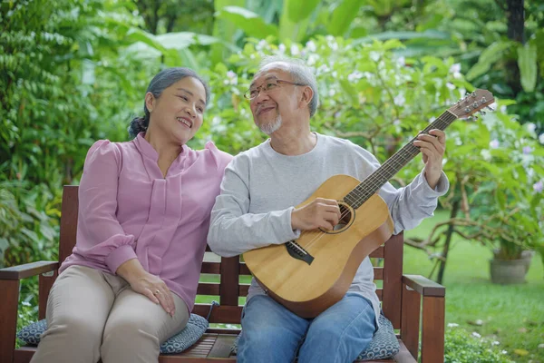 아시아인 밖에서 노래하는 기타를 활동성 생활을 즐기는 노인들 — 스톡 사진