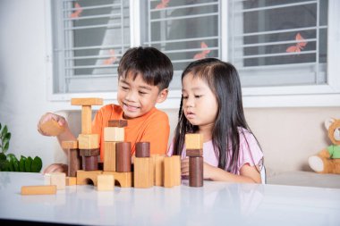 Children boy and girl playing with constructor wooden block building, Happy little kids play wood block stacking board game at home, activities learning creative, toys for preschool and kindergarten