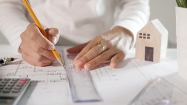 Mimari proje işyeri. Mimarlık bürosundaki masa başı tamir aletleri için ev planı taslağı üzerinde cetvel olan mimar çizimi, mimarlık taslak çizimi, mühendislik araçları