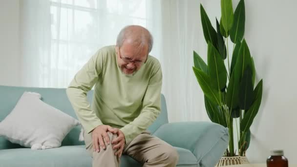 Das Alter Asiatische Senior Mann Ruhestand Kniegelenkschmerzen Auf Dem Sofa — Stockvideo