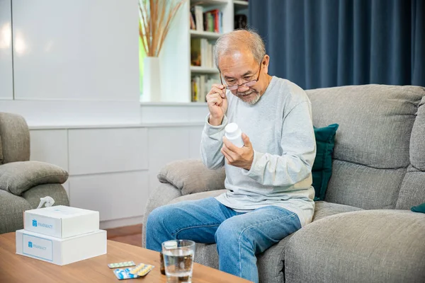 アジアの老人は 彼が服用する前に薬を服用する方法を参照してください薬の丸薬を持つ高齢者を心配し 薬局からハーブ自己治癒Rx錠剤をオンラインで購入します 家庭分離 医療サービスの概念 — ストック写真