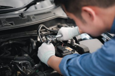 Service outdoor. Asian auto mechanic man working on car engine using wrench to repair and maintenance, broken car care check and fixed the problem and services insurance