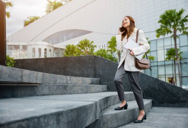 Stepping going up stairs in city, Business woman hold laptop computer talking mobile phone she hurry up walking on stairway, rush hour to work in office a hurry in morning, step up success, Full body