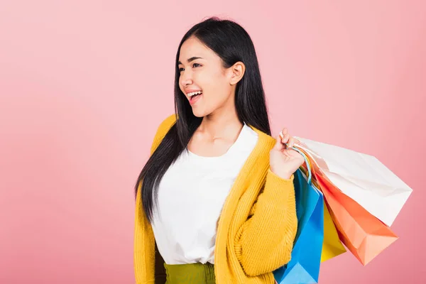 亚洲美丽的年轻女子面带微笑站在网上 兴奋地拿着多彩的购物袋 工作室在粉色背景下拍摄 带有复制空间 — 图库照片