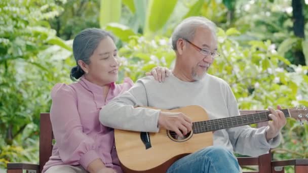 快乐的亚洲老夫老妻一边在户外唱歌一边弹吉他 享受家庭保健 在退休生活中享受老年生活的乐趣 — 图库视频影像