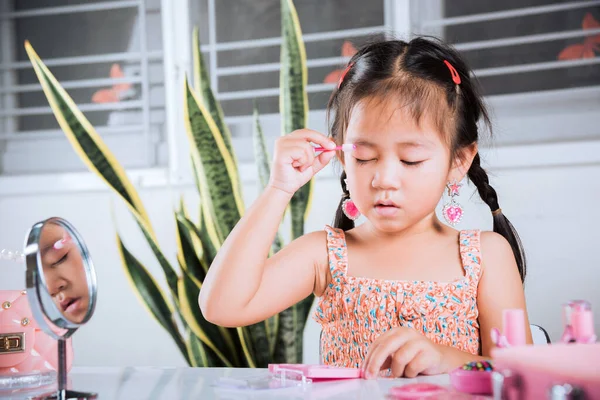 亚洲可爱有趣的小女孩化妆她用碳化硅眼药水涂眼睑 学习做女人的活动 快乐的孩子用化妆品玩具化妆漂亮 — 图库照片