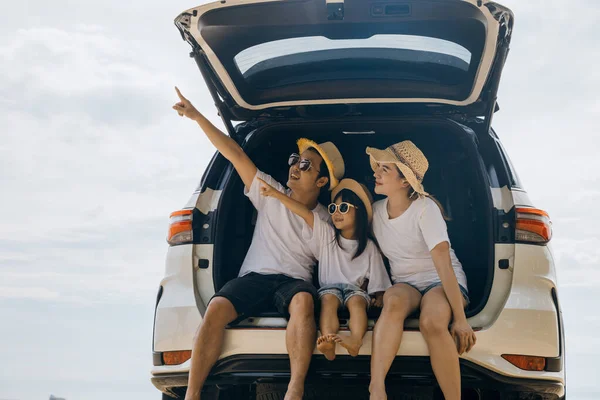 観光の日 お父さん お母さん 娘さんが車の後ろに座って青空を指差して道路旅行を楽しんで 夏休みにビーチで楽しんで 海のビーチで休日に家族旅行 — ストック写真