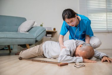 Engelli, yaşlı bir hasta bastonuyla yere düştü ve bakım evinde genç bir asistan, Asyalı yaşlı bir adam yere düştü ve kadın hemşire destek için geldi.