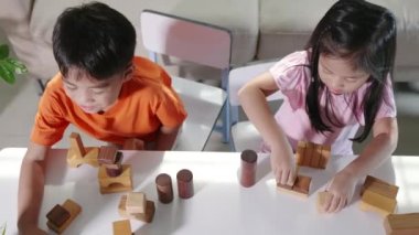 Children boy and girl playing with constructor wooden block building, Happy little kids play wood block stacking board game at home, activities learning creative, toys for preschool and kindergarten