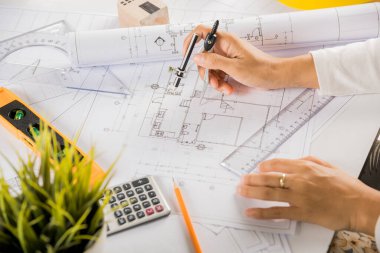 Mimari proje işyeri. Mimarlık bürosundaki masa masasında tamir aletleri için pusula üzerine pusula çizen mimar, inşaat projesi çizen mühendis.