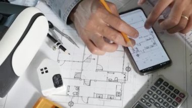 Mimar işyeri. Mimari bina tasarımı ve proje planları, kağıt planları, akıllı cep telefonu ekranı tarafından çevrimiçi insan düzenleme veya mimari denetimi tasarlanması